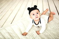 Baby boy in toddler and mouse hat on wooden floor
