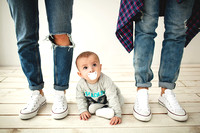 Hipster father, mother and baby boy on rustic wooden floor