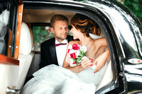 Bride and groom sitting in wedding car
